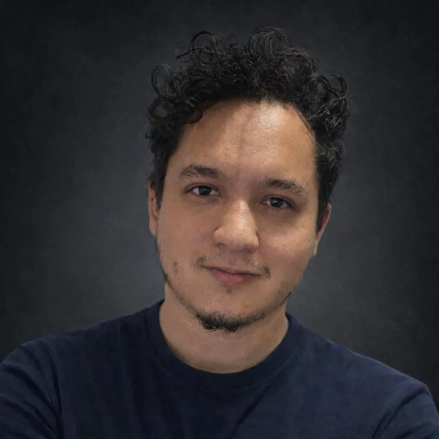 Juan Diego Rivero Tirado, de pelo rizado y camiseta azul oscuro, sobre un fondo gris.
